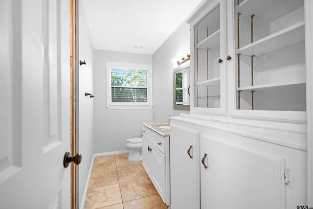 a spacious bathroom with a granite countertop sink a mirror and a shower