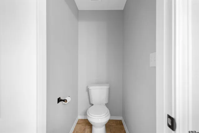 a white toilet sitting next to a white cabinet