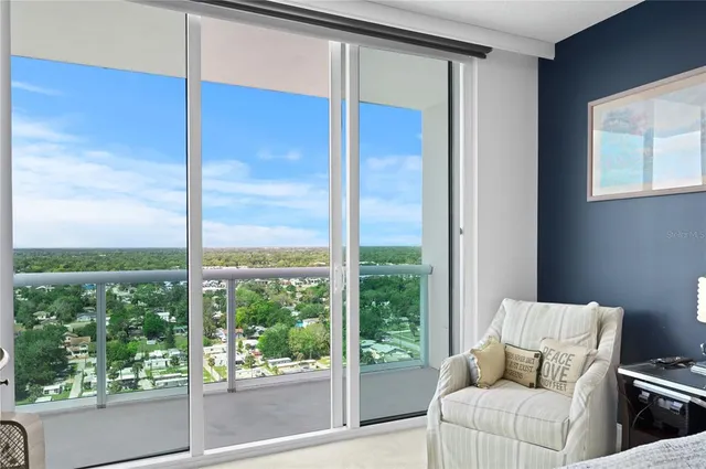 a living room with furniture and a floor to ceiling window