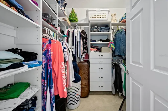 a view of walk in closet with clothes and shoes