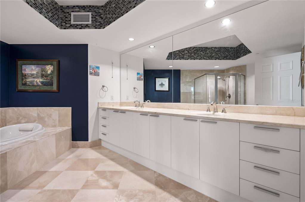 241 Riverside Drive, Unit 1909 Daytona Beach, FL 32117 - Photo 18 of 50 a spacious bathroom with a sink a large mirror and a bathtub