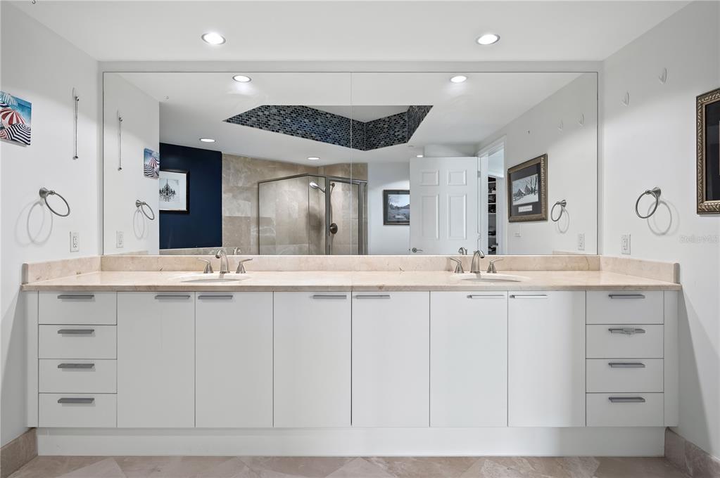 241 Riverside Drive, Unit 1909 Daytona Beach, FL 32117 - Photo 19 of 50 a bathroom with a double vanity sink and a mirror