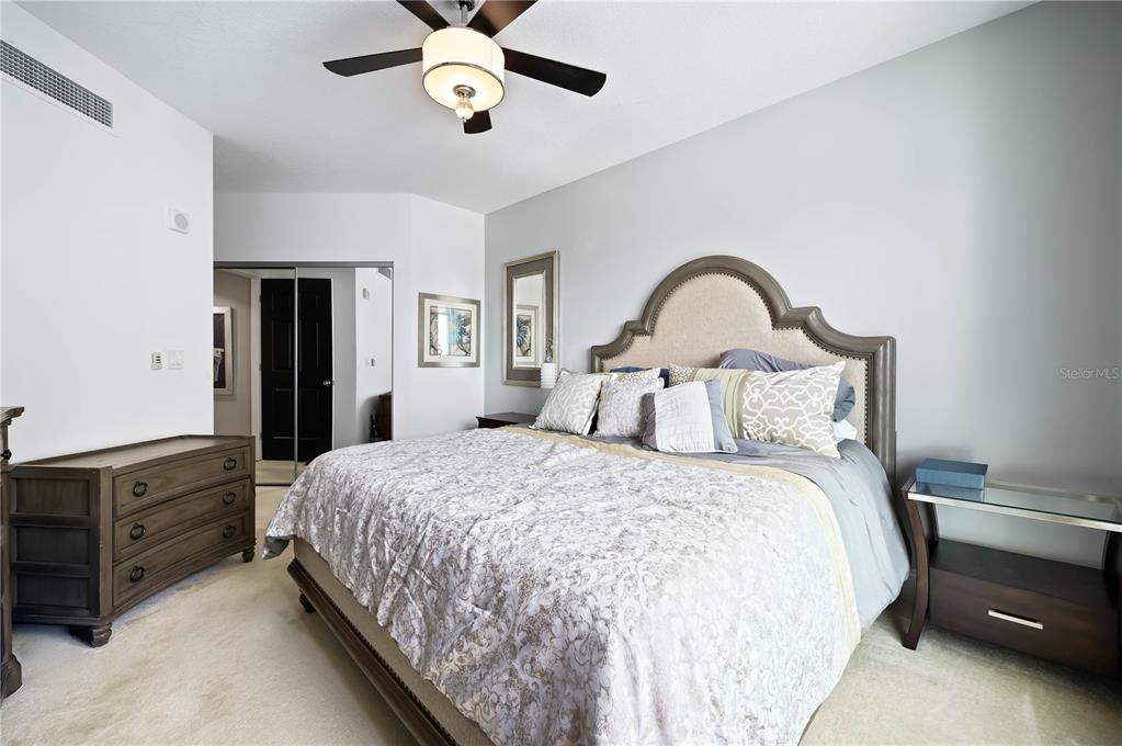 241 Riverside Drive, Unit 1909 Daytona Beach, FL 32117 - Photo 23 of 50 a bedroom with bed and a chandelier