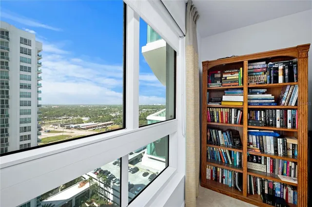 a view of a living room with furniture and book shelf