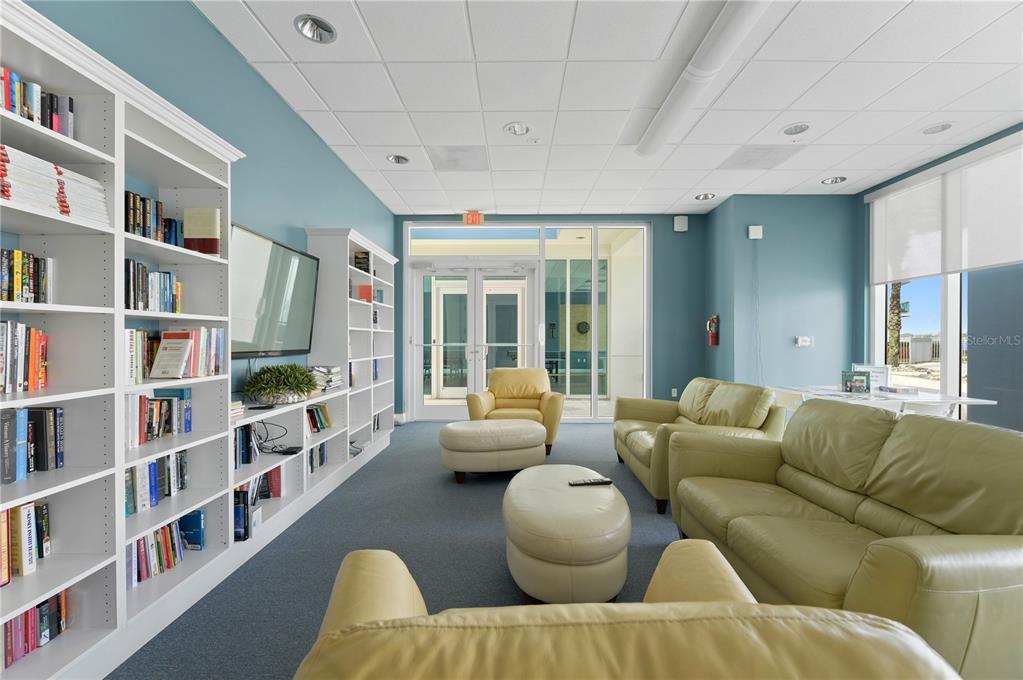 241 Riverside Drive, Unit 1909 Daytona Beach, FL 32117 - Photo 47 of 50 a living room with furniture and a book shelf
