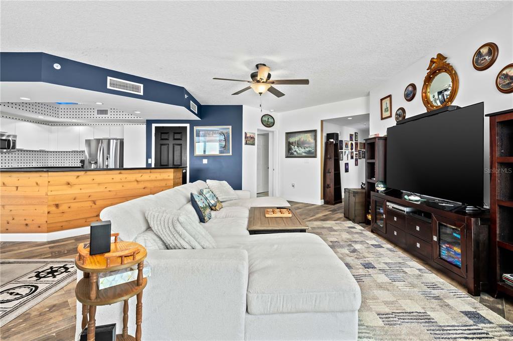 241 Riverside Drive, Unit 1909 Daytona Beach, FL 32117 - Photo 7 of 50 a living room with furniture and a flat screen tv