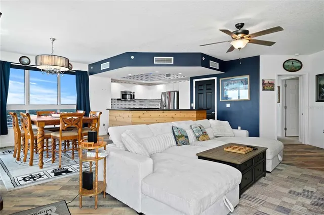 a living room with furniture kitchen view and a chandelier