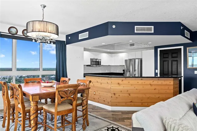 a dining table chairs next to a window