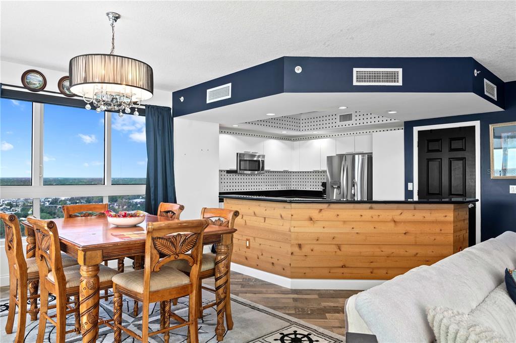 241 Riverside Drive, Unit 1909 Daytona Beach, FL 32117 - Photo 9 of 50 a dining table chairs next to a window