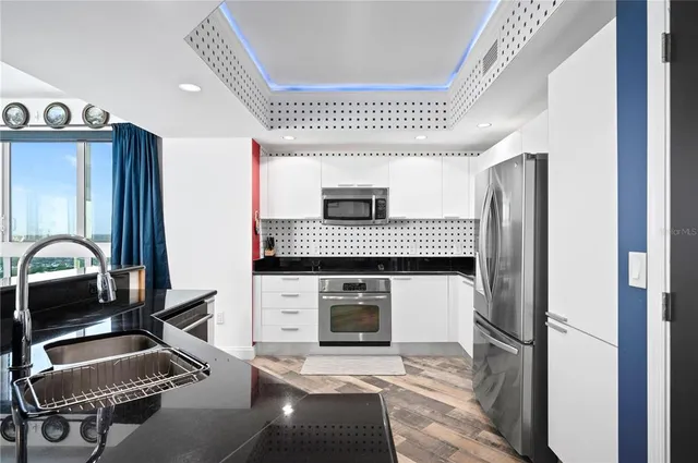 a kitchen with a refrigerator a sink and a stove top oven