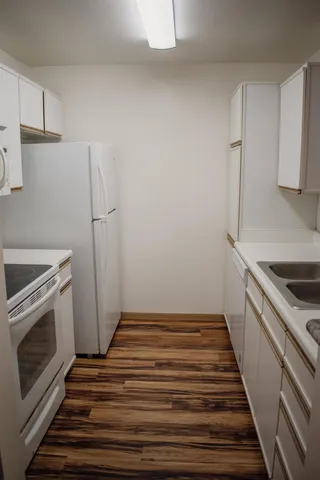 a view of a kitchen with white cabinets and stainless steel appliances