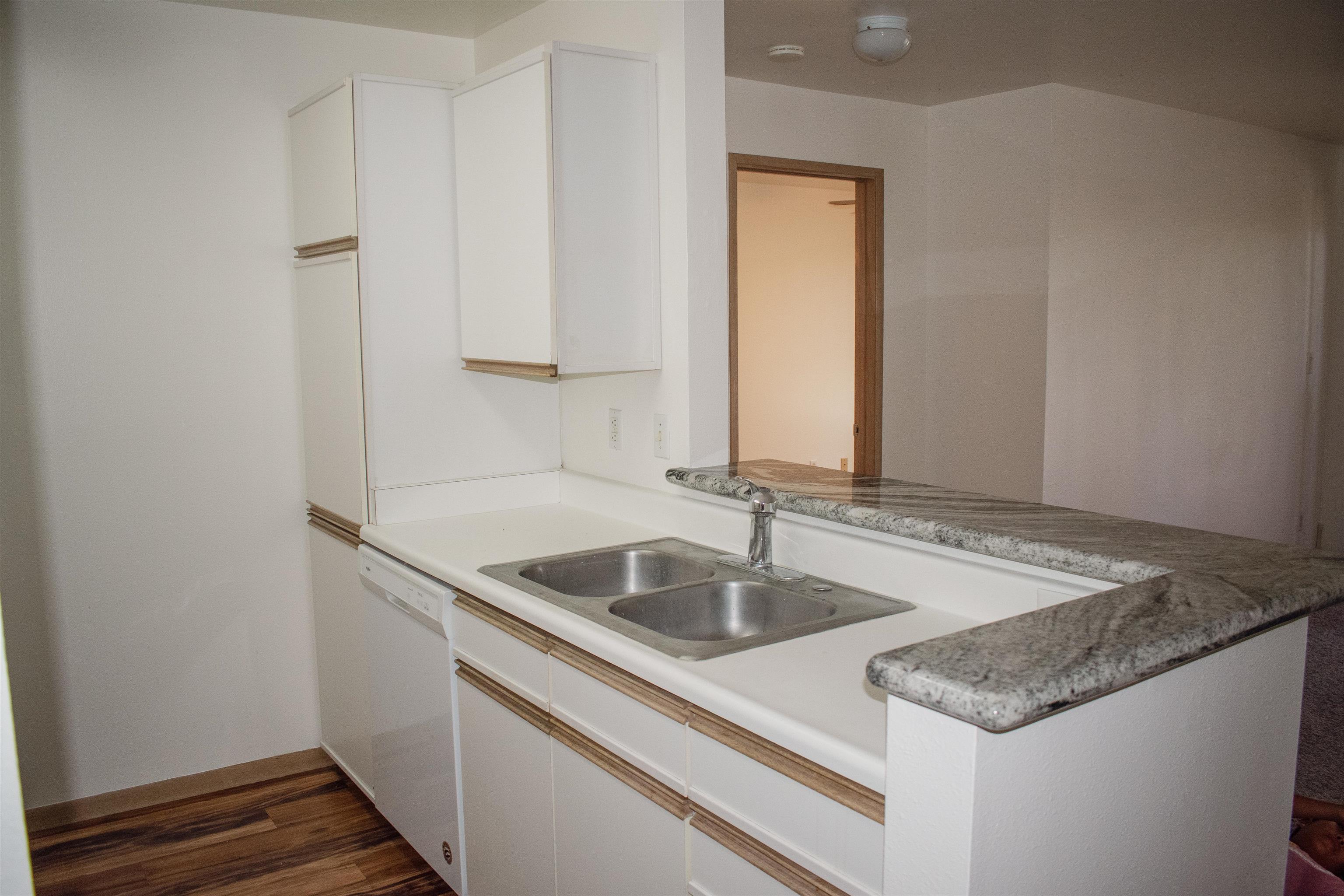 64 Kunihi Lane, Unit 324 Kahului, HI 96732 - Photo 6 of 31 a kitchen with a sink and a wooden floor