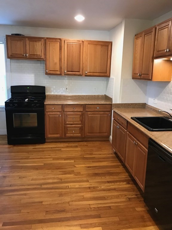 120 Lake Street Boston, MA 02135 - Photo 6 of 28 a kitchen with stainless steel appliances granite countertop a sink and a stove