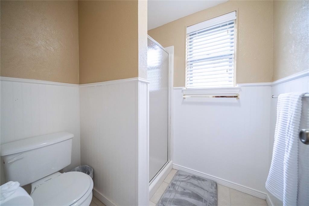 919 Green Hills Road Duncanville, TX 75137 - Photo 27 of 37 Bathroom featuring wainscoting, a shower stall, and toilet
