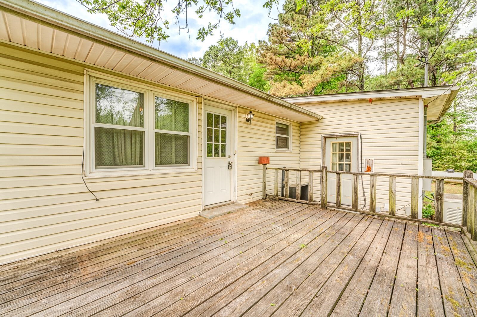6125 Warren Road Oakland, TN 38060 - Photo 34 of 40 Exterior wood deck with a door and multiple windows, featuring horizontal siding