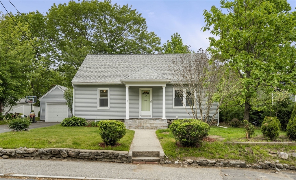 a front view of a house with a yard and potted plants