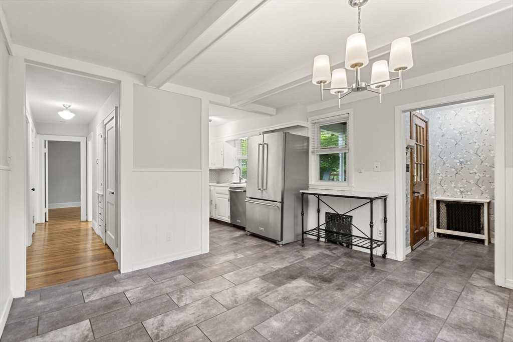 5 Walker Avenue Andover, MA 01810 - Photo 4 of 23 a view of a livingroom with a fireplace a chandelier a kitchen and chandelier
