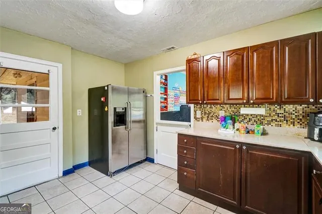a kitchen with stainless steel appliances granite countertop a refrigerator and a stove top oven