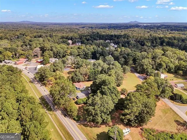an aerial view of a house with garden space and trees