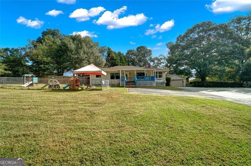 5099 Austell Powder Springs Road Austell, GA 30106 - Photo 34 of 38 a house view with swimming pool and trees in the background