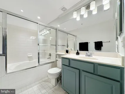 a bathroom with a toilet sink a mirror and shower