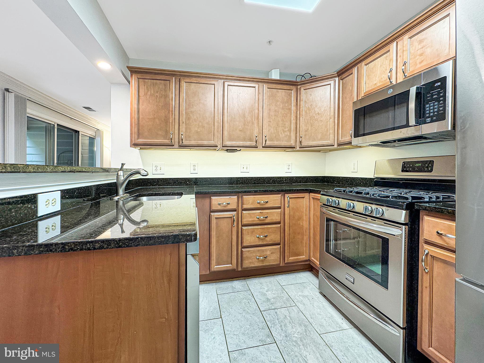 103 Timberbrook Lane, Unit 104 Gaithersburg, MD 20878 - Photo 25 of 35 a kitchen with stainless steel appliances granite countertop a sink stove and microwave
