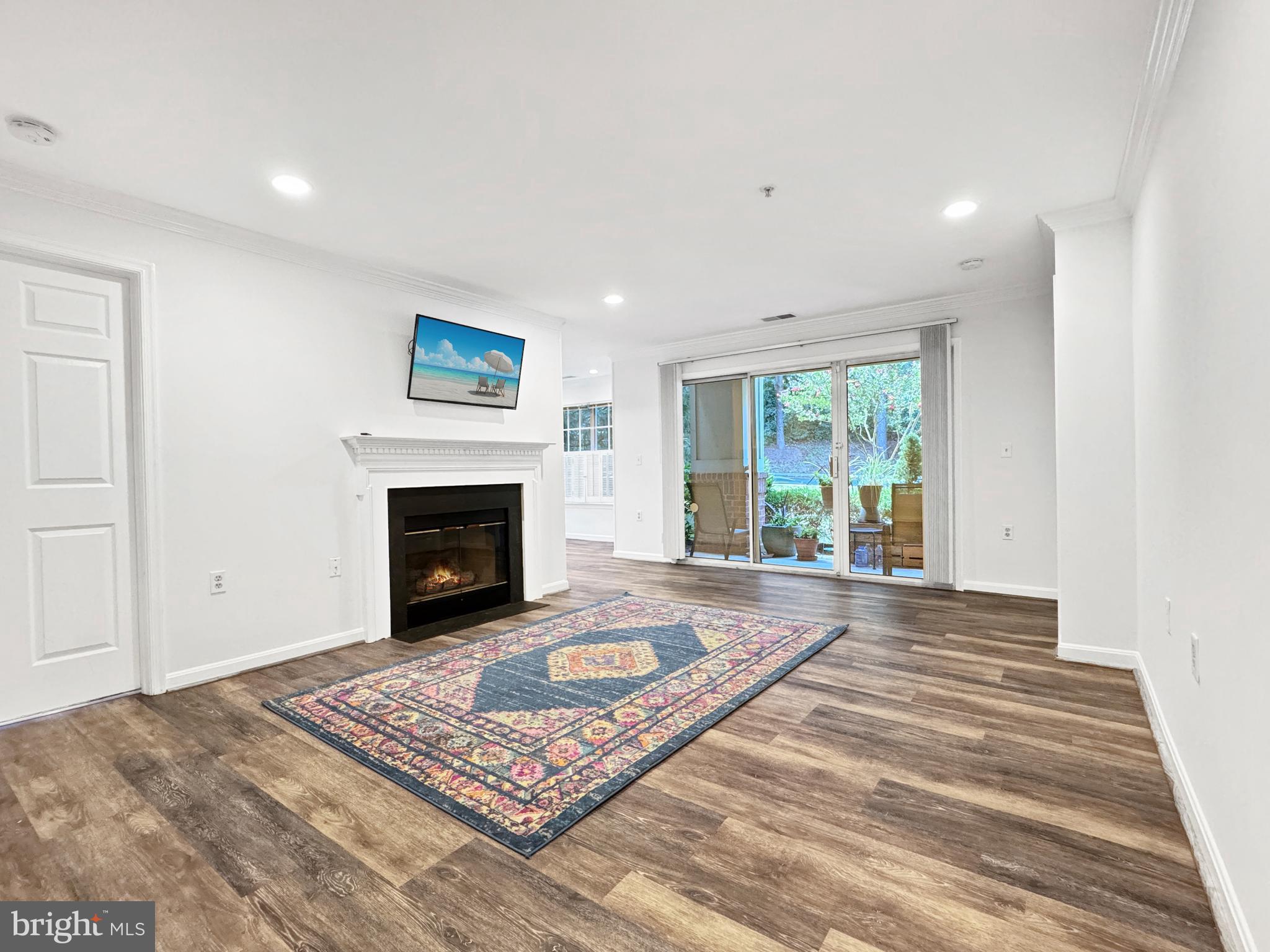 103 Timberbrook Lane, Unit 104 Gaithersburg, MD 20878 - Photo 4 of 35 a view of a livingroom with an empty space and a fireplace
