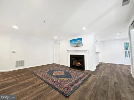 a view of empty room with wooden floor and fireplace