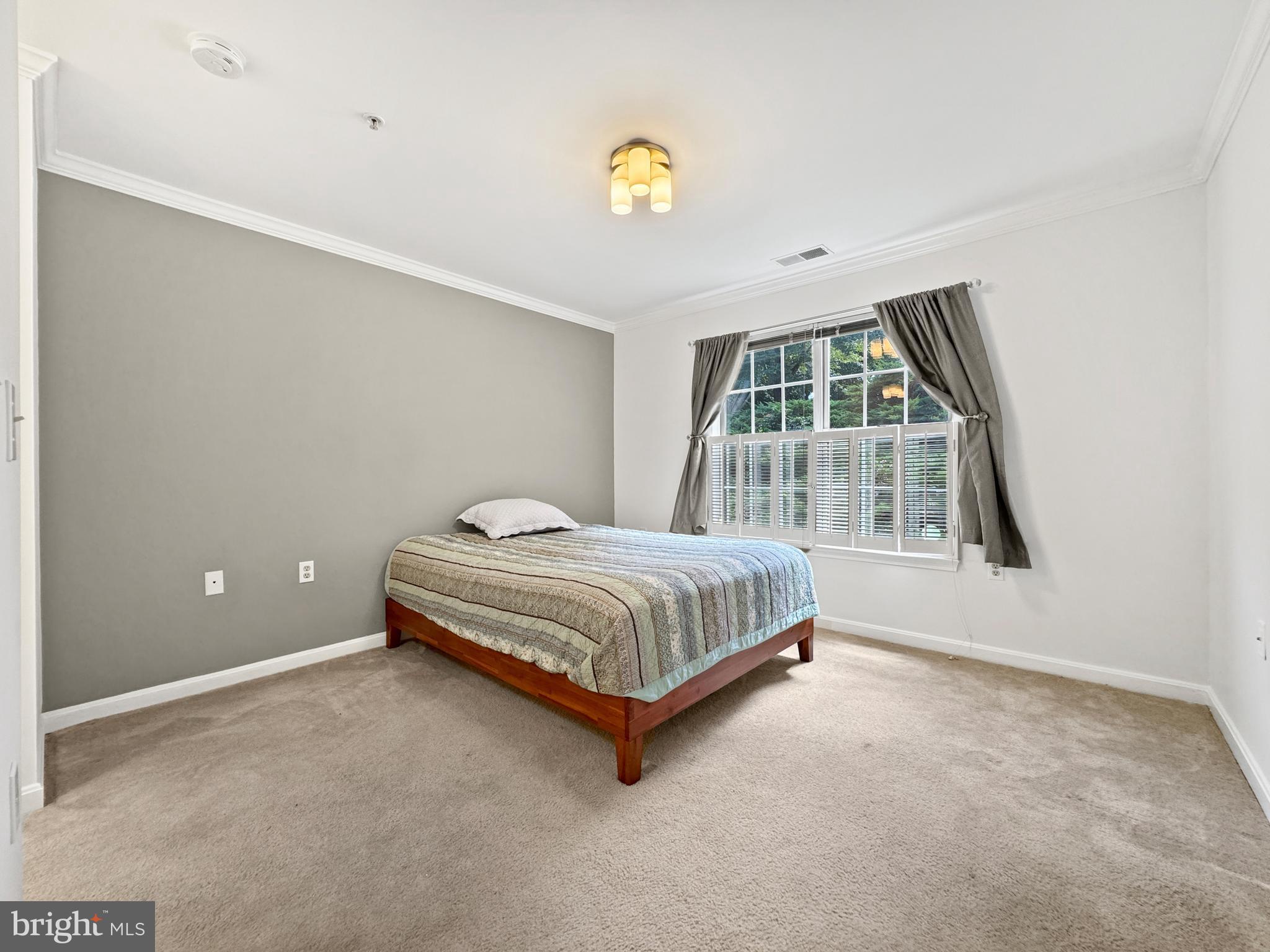 103 Timberbrook Lane, Unit 104 Gaithersburg, MD 20878 - Photo 8 of 35 a spacious bedroom with a bed and a window