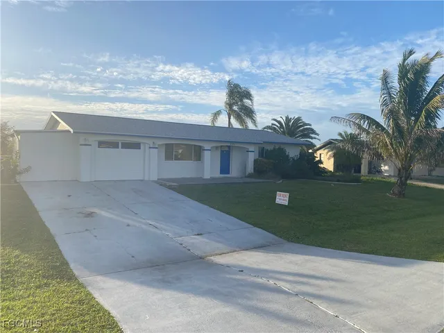 a front view of a house with a garden and yard