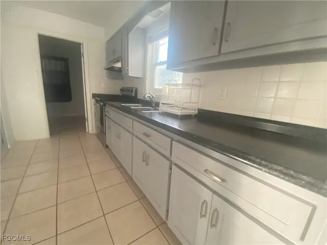 a large kitchen with a stove and a sink
