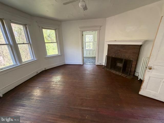 718 Woodlane Road Beverly, NJ 08010 - Photo 17 of 22 an empty room with wooden floor fireplace and windows