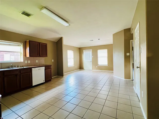a large kitchen with a stove a sink dishwasher and a refrigerator