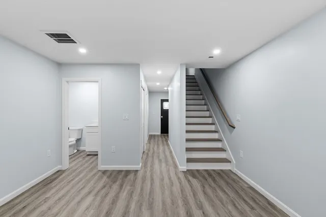 a view of a hallway with wooden floor and stairs