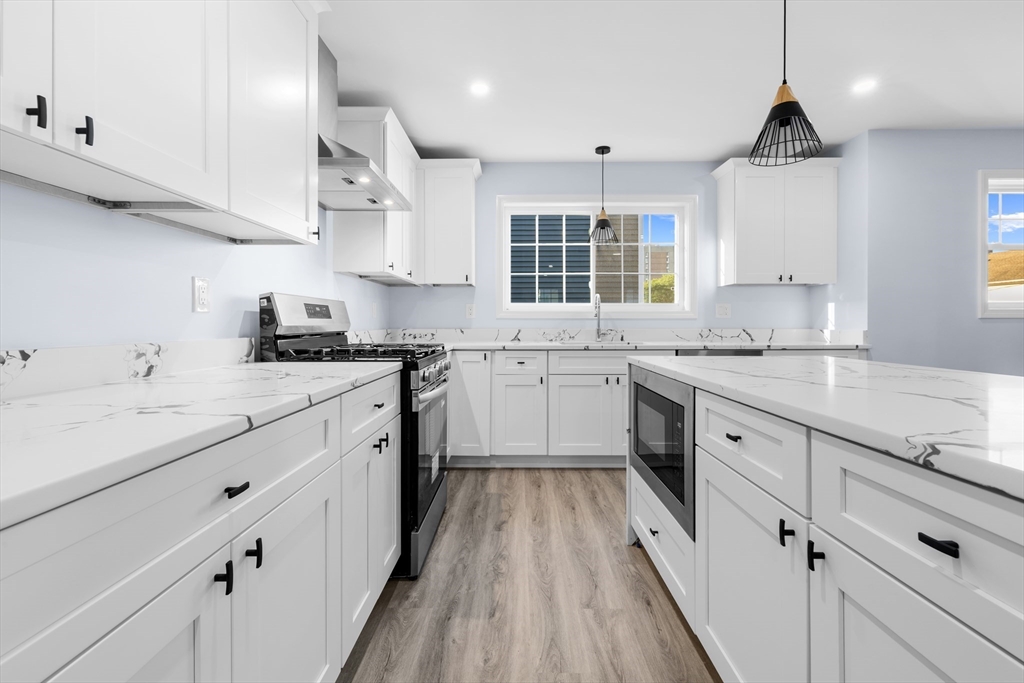 81 Hunter Street Fall River, MA 02721 - Photo 5 of 15 a kitchen with granite countertop a sink cabinets a counter space and stainless steel appliances