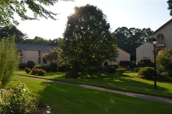 a view of a house with backyard garden and sitting area