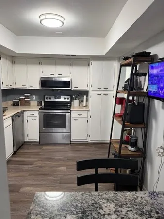 a view of a kitchen with fridge and wooden floor
