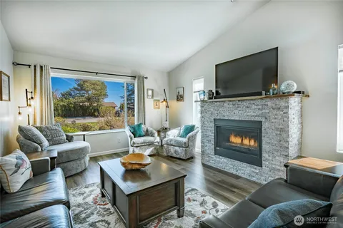 a living room with furniture a flat screen tv and a fireplace