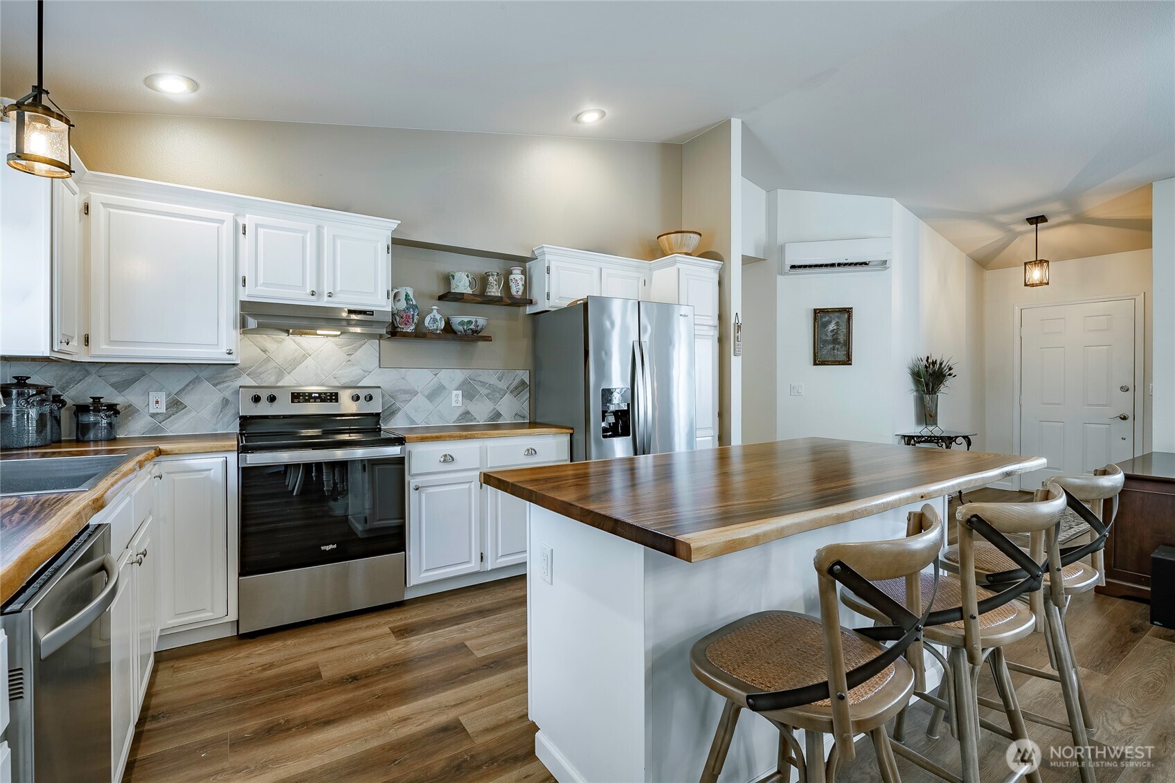 8209 Comox Road Birch Bay, WA 98230 - Photo 6 of 24 a kitchen with stainless steel appliances granite countertop a sink a stove a refrigerator cabinets and a dining table with wooden floor