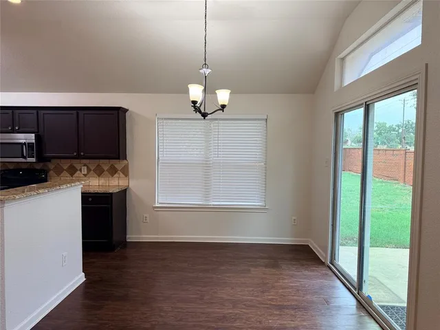 a kitchen with kitchen island granite countertop a stove a sink and a wooden floors