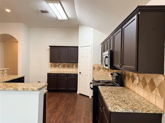a view of living room with granite countertop couch and a flat screen tv