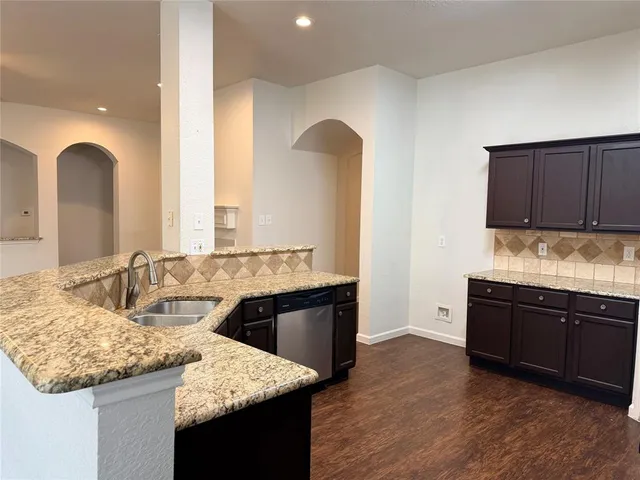 a kitchen with granite countertop cabinets and wooden floor
