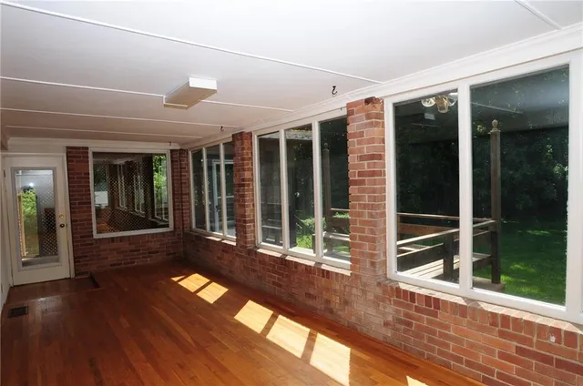 a view of front door with porch and wooden floor