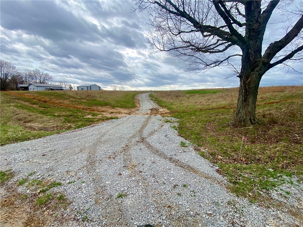This expansive lot features a gravel driveway, offering privacy and direct access to potential building sites.