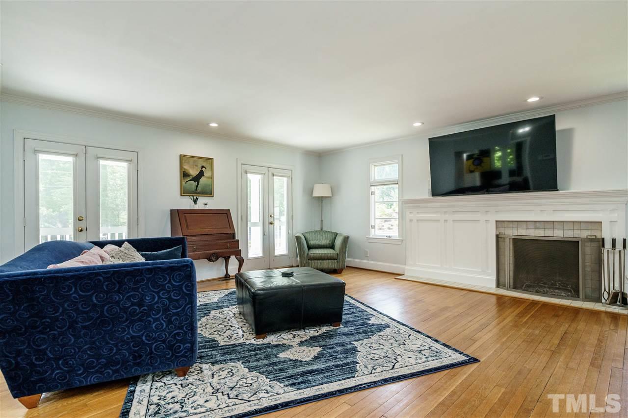 1001 Canterbury Road Raleigh, NC 27607 - Photo 11 of 29 a living room with furniture a flat screen tv and a fireplace