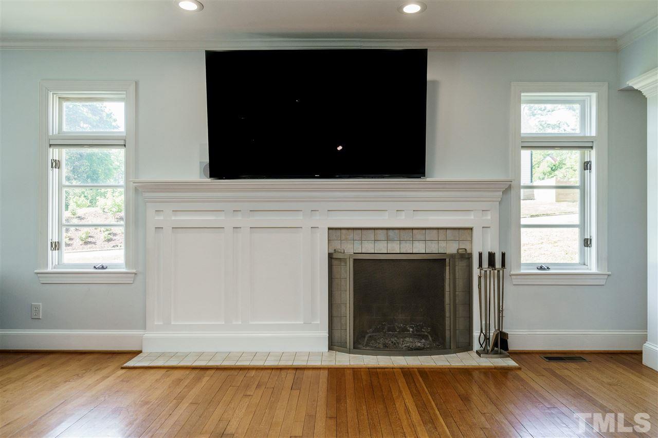 1001 Canterbury Road Raleigh, NC 27607 - Photo 12 of 29 a living room with a fireplace and wooden floor