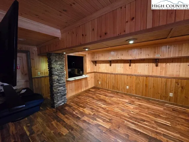 a view of an empty room with wooden floor and a cabinet