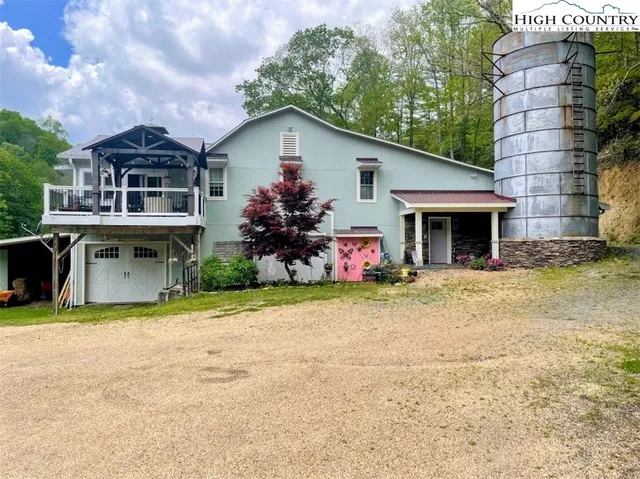 a view of a house with a yard and potted plants