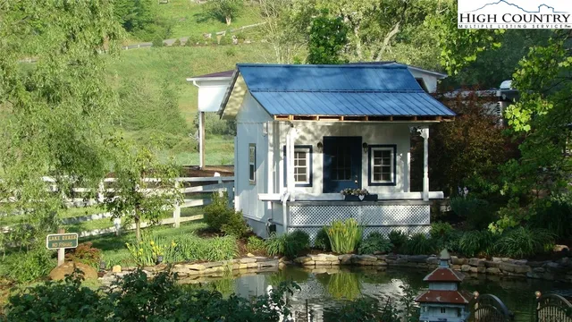 a view of small house with yard and sitting area
