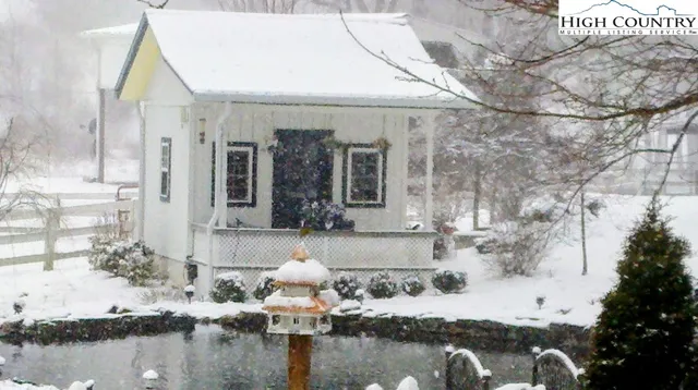 a view of a house with pool and sitting area